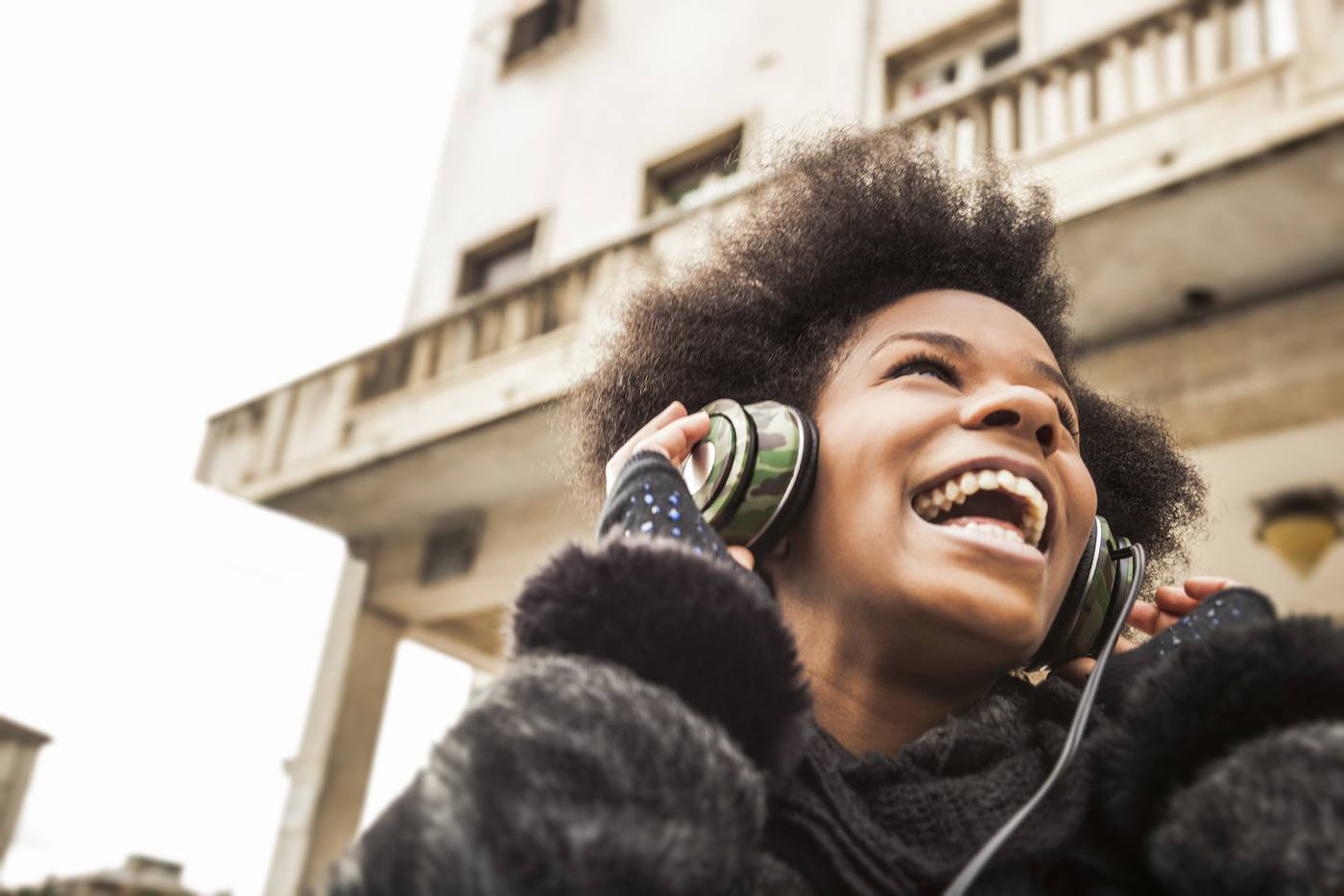 woman with headphones smiling outdoors