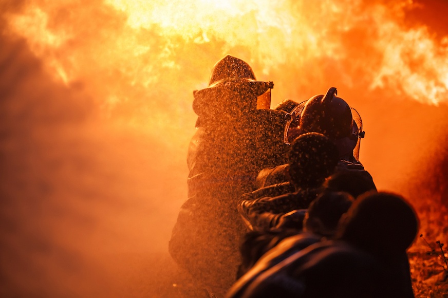 Firefighters lined up to combat a raging fire