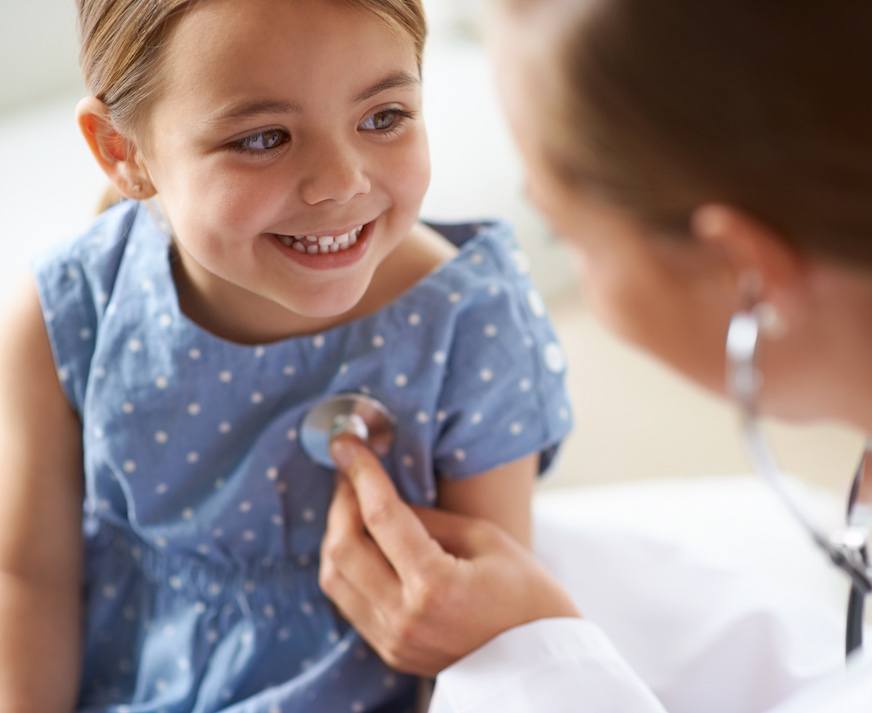 Doctor using a stethoscope on a smiling girl