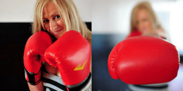 Blonde Woman Holding Up Fists in Boxing Gloves