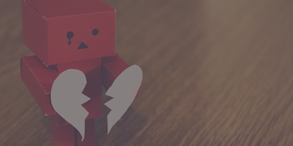 Red Robot Holding a White Paper Broken Heart