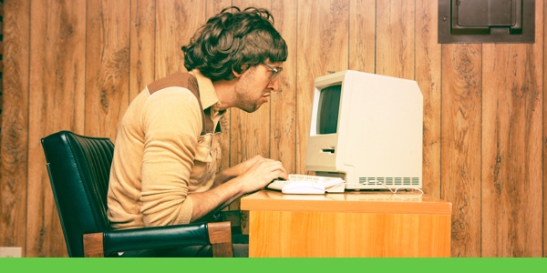 Man hunched over at an 80s computer