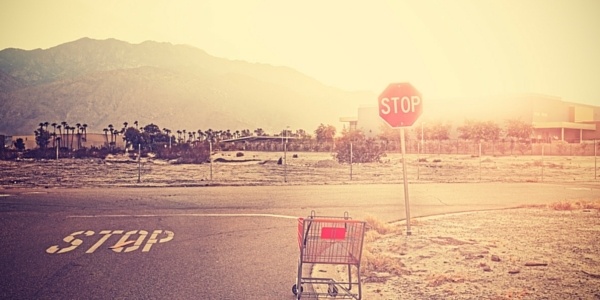Shopping Cart Sitting Next to a Stop Sign