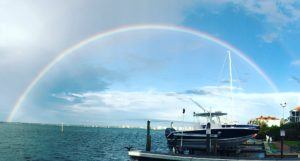 Rainbow Across An Ocean Behind a Marina 